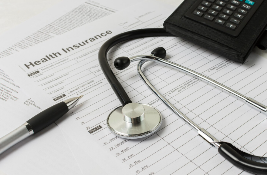 health insurance terms explained with stethoscope, calculator, and policy documents