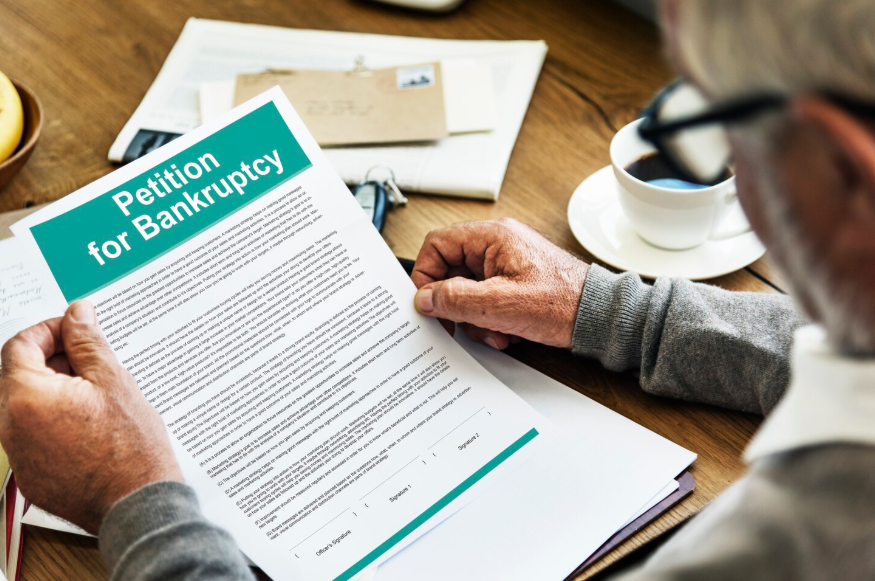 person reviewing petition for bankruptcy document at table